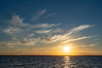 Sun Falling in to the sea. A Spectacular golden Sunset in the ocean with puffy clouds on the sky
