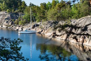 Sailboat anchored near remote rocky island in Stockholm archipelago, Sweden