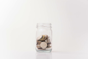 Pile of money coins in piggy bank with white background, saving money and financial concept, copy space