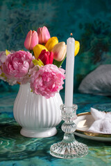 a white vase with flowers and a glass of wine on the table. Romantic table setting