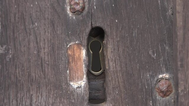Looking through key hole of an old door from a church spy in UK 4K
