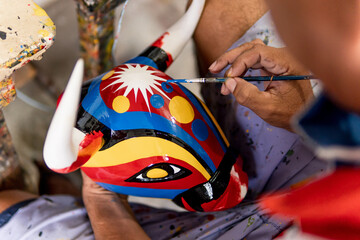 hands painting bull mask carved in wood and painted with commemorative colors of the carnival of barranquilla colombia