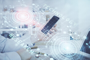 Double exposure of man's hand holding and using a digital device and data theme hologram drawing. Technology concept.
