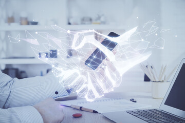 Double exposure of man's hands holding and using a digital device and handshake drawing. Partnership concept.