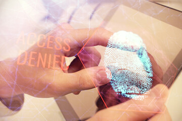 Double exposure of man's hands holding and using a digital device and fingerprint hologram drawing. Security concept.