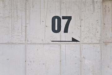 Exposed concrete wall with the number 07 on it