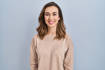 Obraz premium Young woman standing over isolated background with a happy and cool smile on face. lucky person.