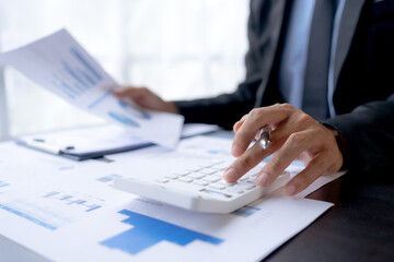 Businessman using calculator to check finance, accounting, income and company budget.