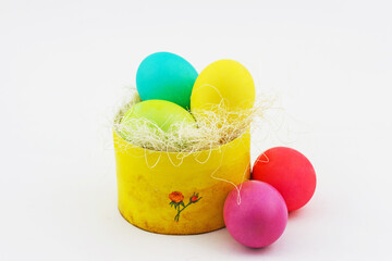 Happy Easter concept. Handmade box full of colorful painted eggs in a hay on white background