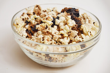 Burnt popcorn from a home microwave. Burn corn kernels on the kitchen table