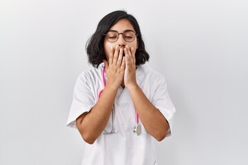 Young hispanic doctor woman wearing stethoscope over isolated background bored yawning tired covering mouth with hand. restless and sleepiness.