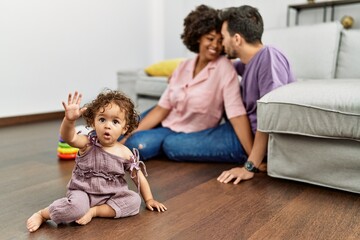 Fototapeta premium Couple and daughter smiling confident playing with toys sitting on the floor at home