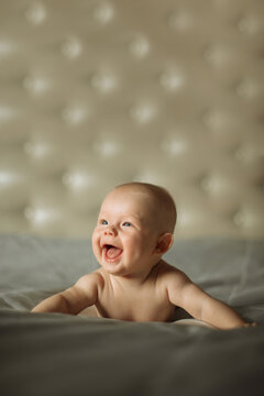 Portrait of a cute newborn boy, looking with interested on something while trying crawling at isolated studio