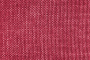 Jacquard woven upholstery, bright red coarse fabric texture. Textile background, furniture textile material, wallpaper, backdrop. Cloth structure close up.
