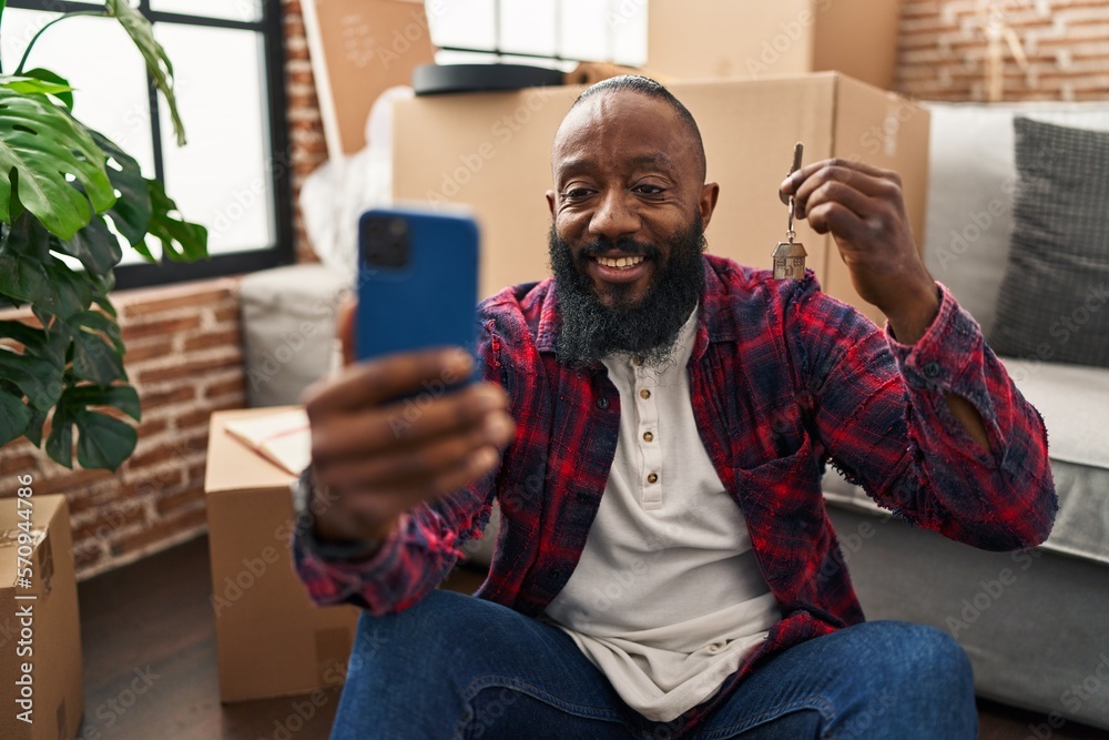 Poster Young african american man make selfie by the smartphone holding key of new house at new home