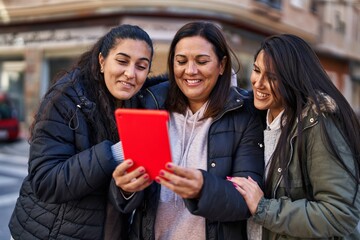Three woman mother and daughters having video call at street