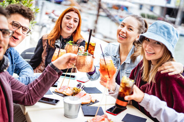 Trendy friends taking selfie at fancy restaurant out side - Life style concept with young people having fun together on happy hour at sidewalk cocktail bar - Vivid filter with shallow depth of field