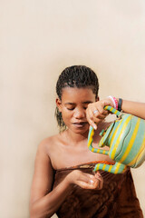 Pretty woman wearing a loincloth and toileting (using a teapot). Young Afro beauty, 19 years old, braided hair, photo
