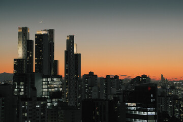 A wonderful landscape where the sun goes down and the gradient sky is visible through the buildings