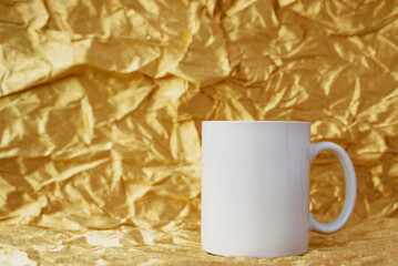 Simple mockup white blank coffee mug on golden background, copyspace. Template for your design.