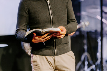 Pastor with a Bible in his hand during a sermon. The preacher delivers a speech