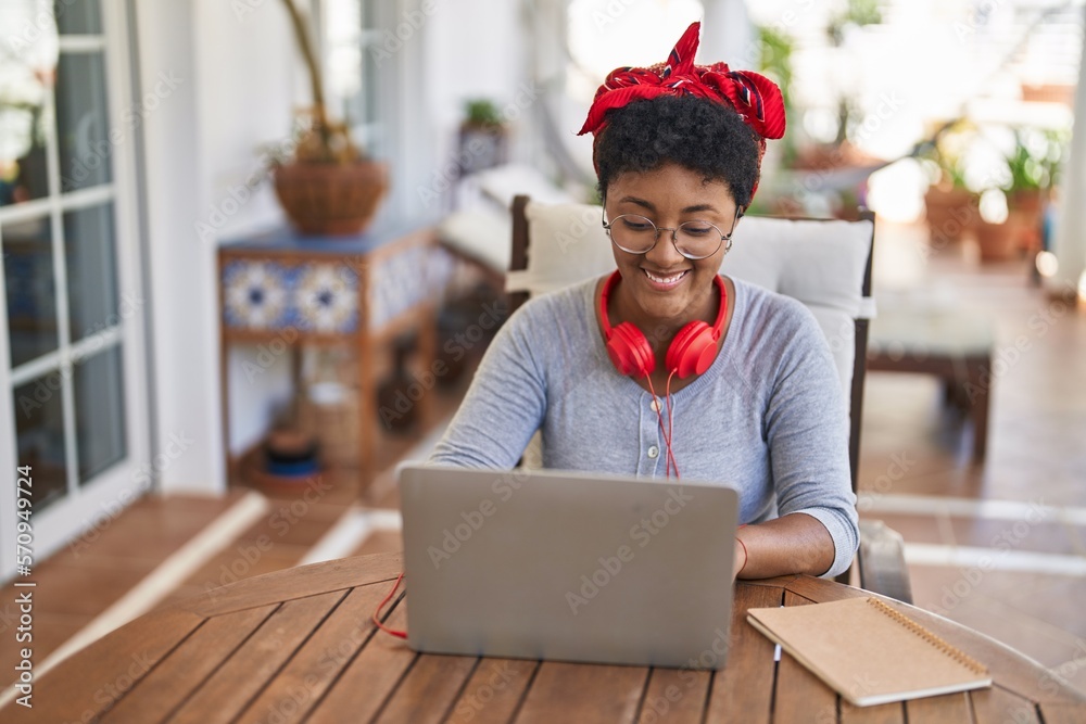 Poster African american woman sitting on table studying at home terrace