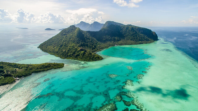Aerial view of Bohey Dulang island panorama, beautiful blue lagoon and coral reef.
