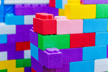 Background, texture, wall, from children's soft colored, multi-colored blocks, bricks on the playground for games. Close-up photography, concept of childhood and construction, macro.