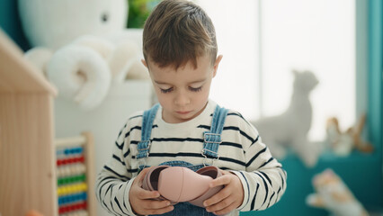 Adorable caucasian boy standing with relaxed expression at kindergarten