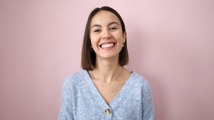 Fototapeta premium Young beautiful hispanic woman smiling confident standing over isolated pink background