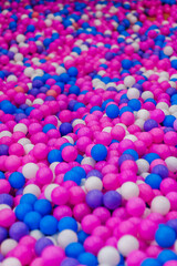 Background, closeup texture of colored, multi-colored round plastic small balls on the playground for children's games.