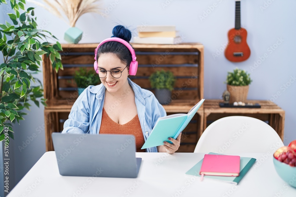 Poster young caucasian woman sitting on table studying at home