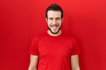 Young hispanic man wearing casual red t shirt with a happy and cool smile on face. lucky person.