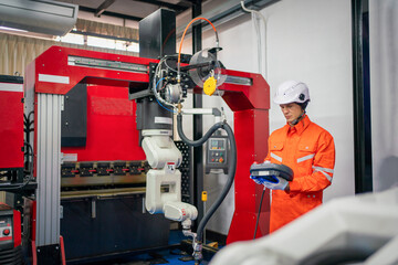 Engineers mechanic using computer controller Robotic arm for welding steel in steel factory...