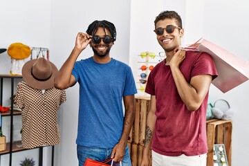 Two men friends wearing sunglasses at clothing store