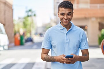 African american man smiling confident using smartphone at street