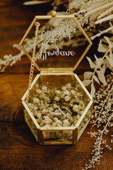 Les alliances des mariés dans leur écrin en verre et laiton