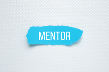 Mentor word written on blue torn paper.