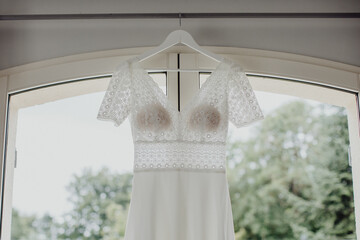 La robe de mariée suspendue à la fenêtre
