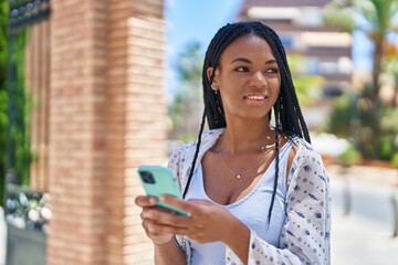 African american woman smiling confident using smartphone at street