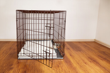 An empty pet cage in the apartment. A wire box or an iron box for keeping animal.