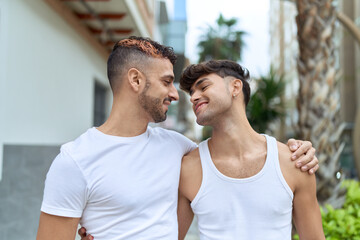 Two hispanic men couple smiling confident hugging each other at street