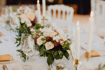 Bouquets de fleurs et bougies allumées sur la table de réception