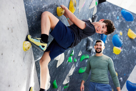 Smiling boy climbing in a bouldering gym