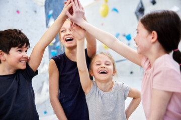 Little kids high fiving in a climbing gym