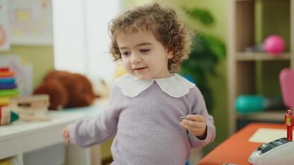 Adorable hispanic girl smiling confident standing at kindergarten