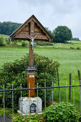 Cross with Jesus Christ crucified with the text, My Jesus mercy, along road. Limburg, Netherlands. Catholic memorial at intersection of roads and streets. Religious expression Christ died on the cross