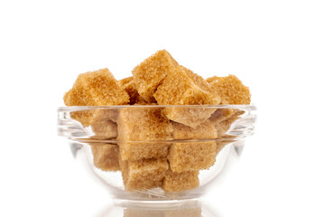 A few cubes of brown sugar in a glass dish, macro, isolated on a white background.