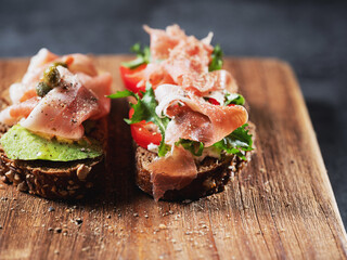 Variety of mini sandwiches with cream cheese, vegetables and salami