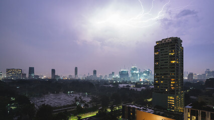 A thunderstorm with lightning in Bangkok with skyscrapers in the background.